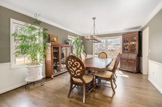 dining room featuring a notable chandelier, wood finished floors, and crown molding