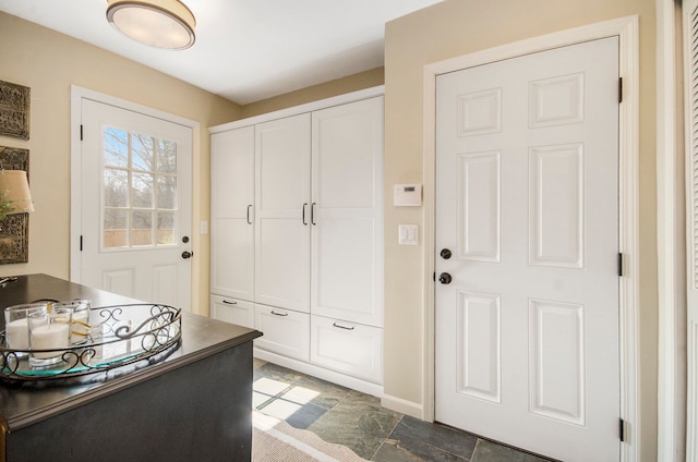 entryway featuring baseboards and stone finish flooring