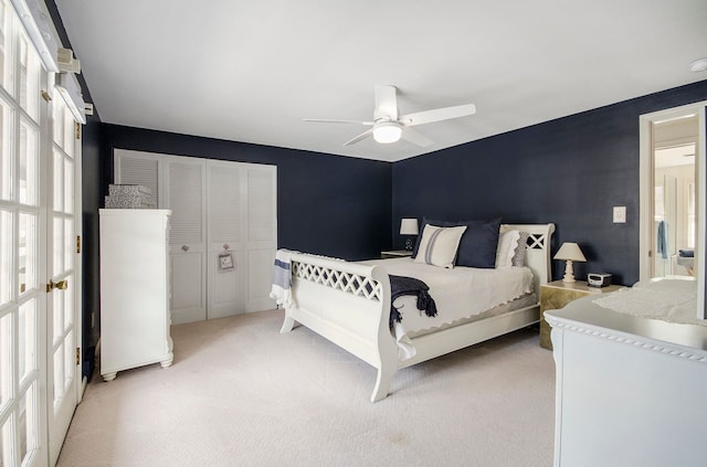 bedroom with a ceiling fan, light colored carpet, and french doors