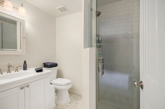 bathroom with vanity, a shower stall, toilet, and visible vents