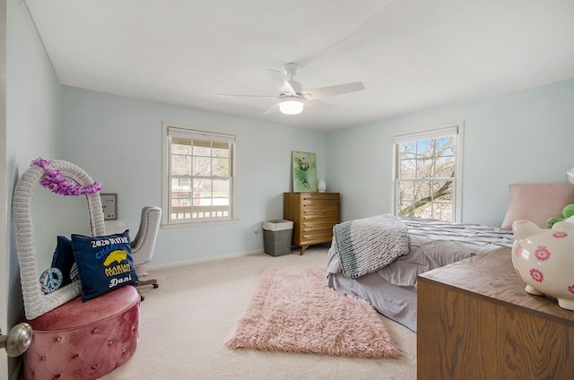 bedroom with carpet flooring, multiple windows, baseboards, and a ceiling fan