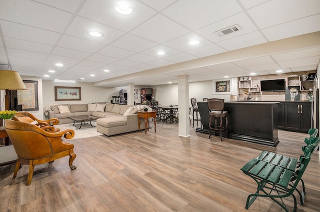 living area featuring recessed lighting, wood finished floors, visible vents, and indoor bar