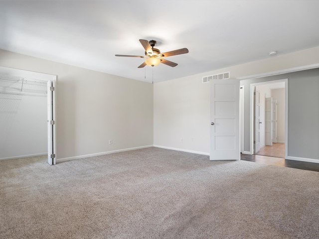 carpeted empty room featuring visible vents, baseboards, and a ceiling fan