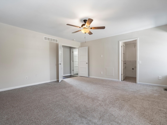 unfurnished bedroom featuring carpet, visible vents, baseboards, ceiling fan, and a spacious closet