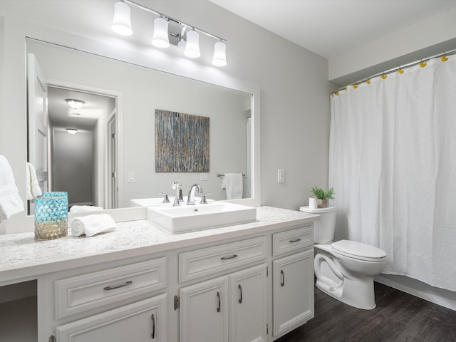 bathroom with a shower with shower curtain, toilet, vanity, and wood finished floors