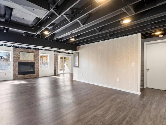 unfurnished living room with a fireplace, baseboards, and wood finished floors