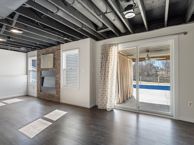 spare room featuring a stone fireplace and wood finished floors