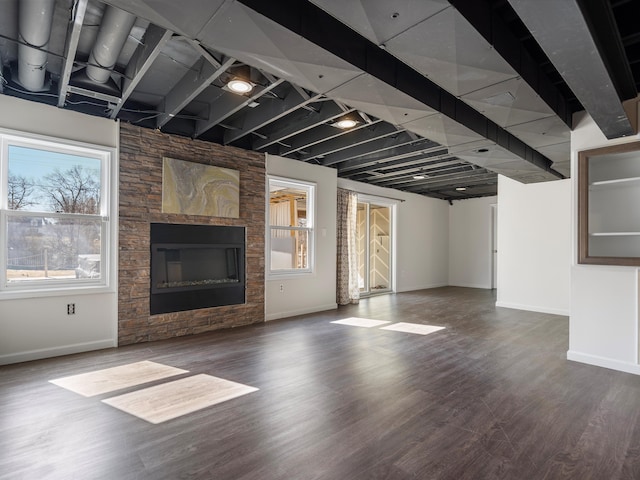 unfurnished living room featuring baseboards, wood finished floors, and a fireplace