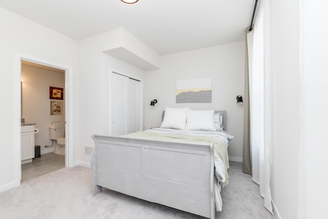 bedroom featuring visible vents, baseboards, light colored carpet, and connected bathroom