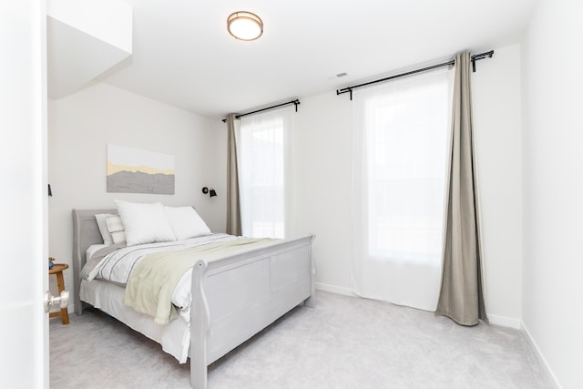 bedroom featuring baseboards and light carpet