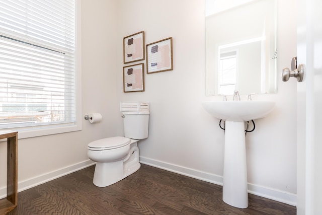 bathroom with toilet, baseboards, and wood finished floors