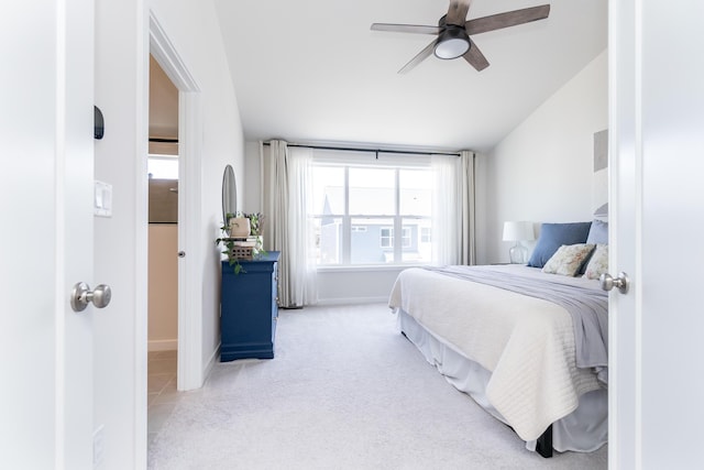 carpeted bedroom featuring vaulted ceiling, a ceiling fan, and baseboards