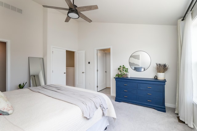 bedroom featuring visible vents, light carpet, high vaulted ceiling, baseboards, and ceiling fan