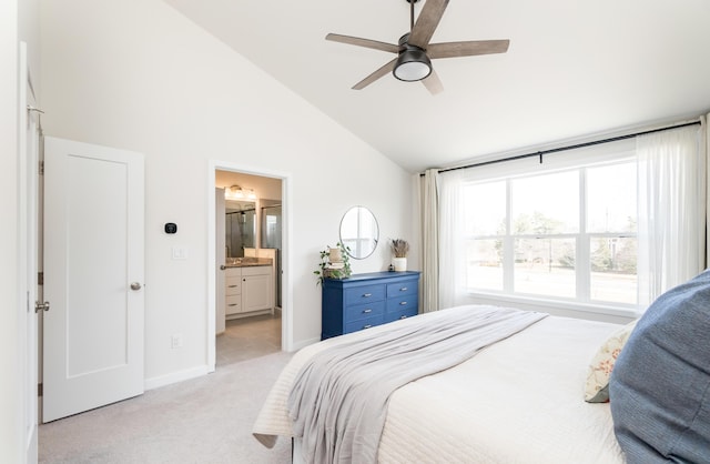 bedroom with light carpet, lofted ceiling, connected bathroom, baseboards, and ceiling fan