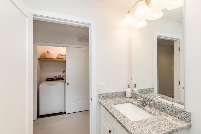 bathroom featuring vanity, washer / clothes dryer, and visible vents