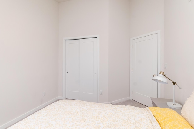 carpeted bedroom featuring a closet and baseboards