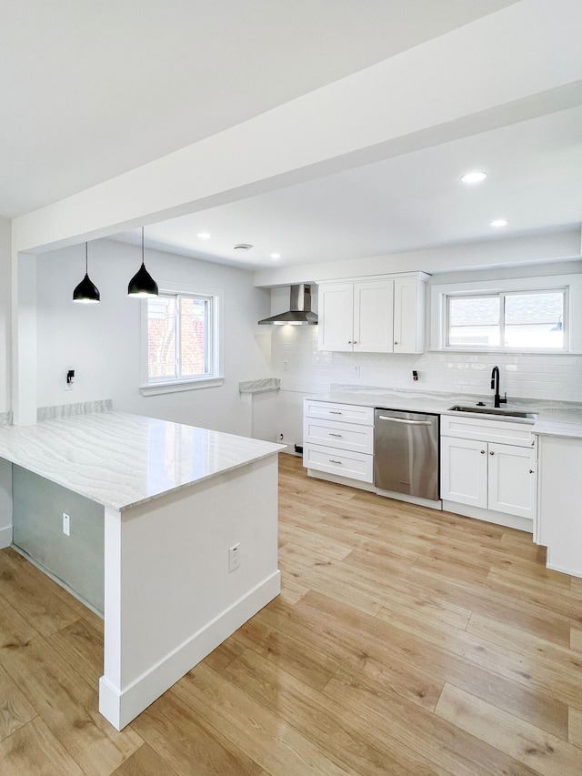 kitchen with a sink, light wood-style floors, stainless steel dishwasher, wall chimney exhaust hood, and tasteful backsplash