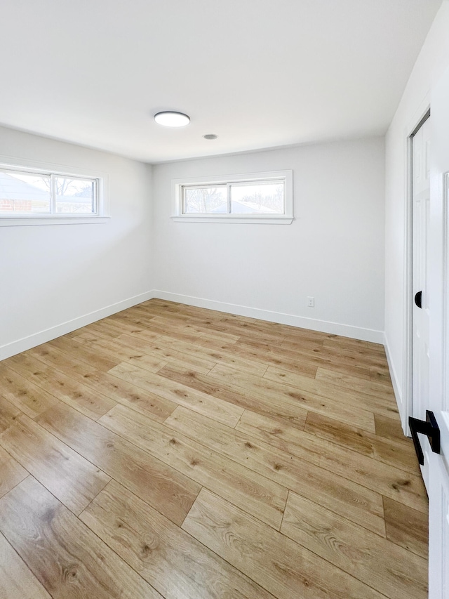 spare room with light wood-type flooring and baseboards