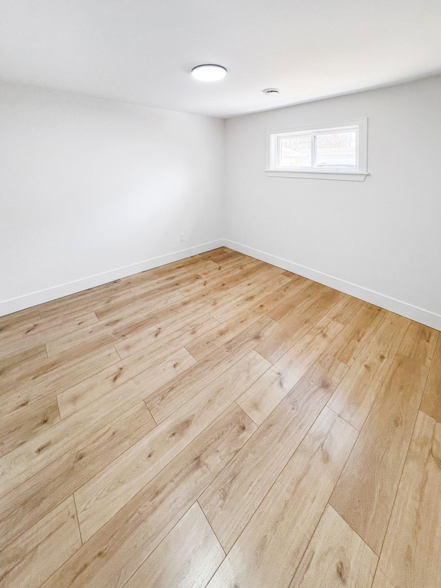 spare room featuring wood finished floors and baseboards