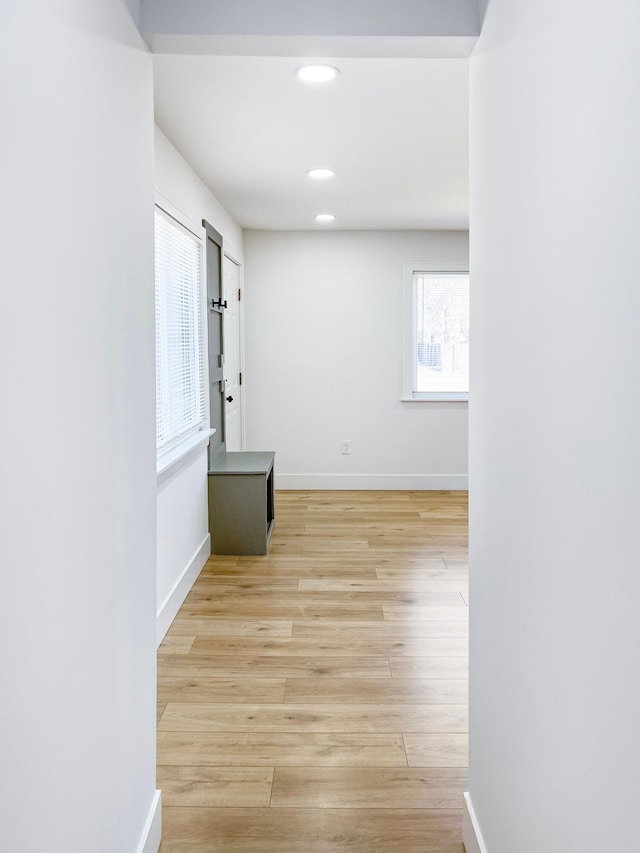 hallway featuring recessed lighting, baseboards, and light wood finished floors