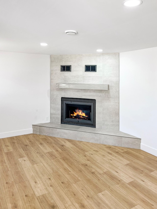 interior details with wood finished floors, recessed lighting, a fireplace, and baseboards