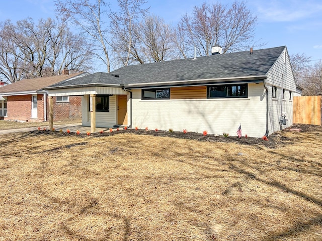 ranch-style house featuring brick siding, a chimney, and fence