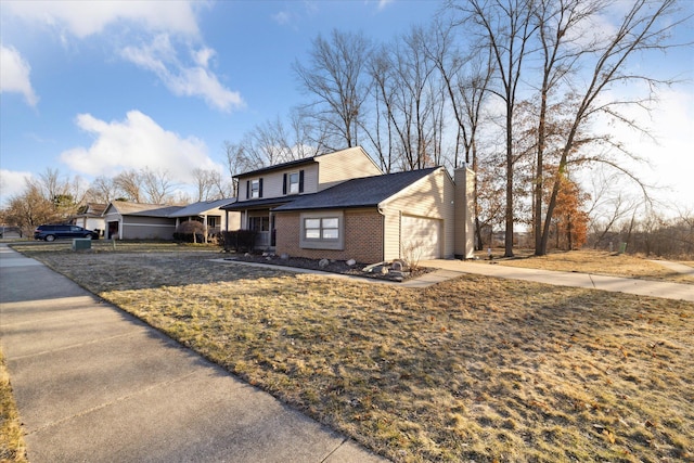 view of front facade with brick siding, concrete driveway, a front yard, a chimney, and a garage