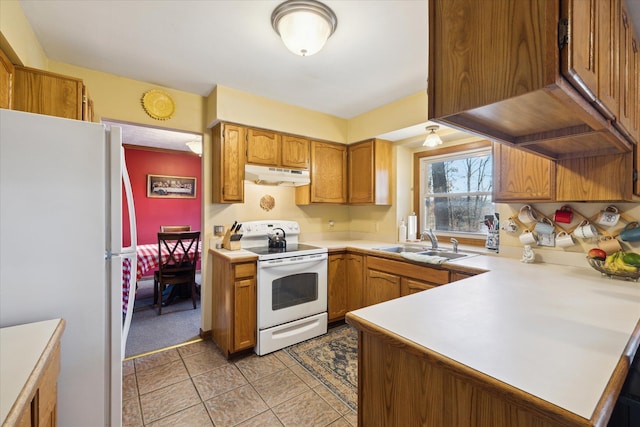 kitchen with under cabinet range hood, light countertops, a peninsula, white appliances, and a sink