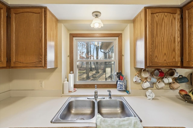 kitchen with brown cabinets, light countertops, and a sink