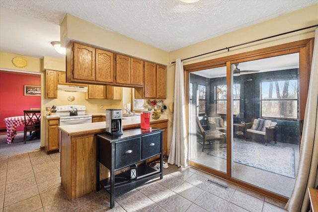 kitchen with under cabinet range hood, light countertops, brown cabinetry, white electric stove, and a textured ceiling