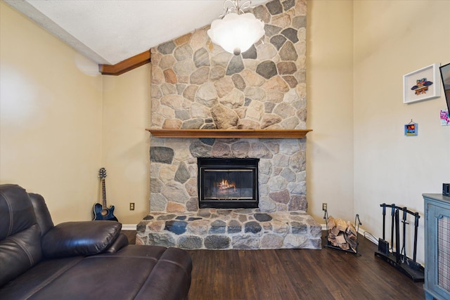 living room with a stone fireplace, lofted ceiling, wood finished floors, and a textured ceiling