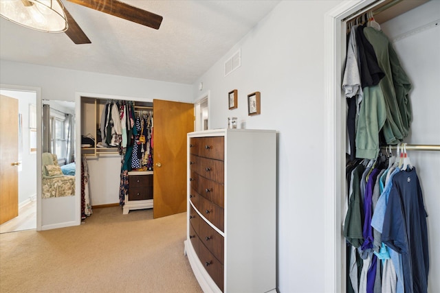 carpeted bedroom with ceiling fan, visible vents, a closet, and baseboards