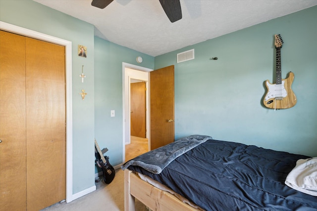 bedroom with visible vents, baseboards, ceiling fan, light carpet, and a textured ceiling