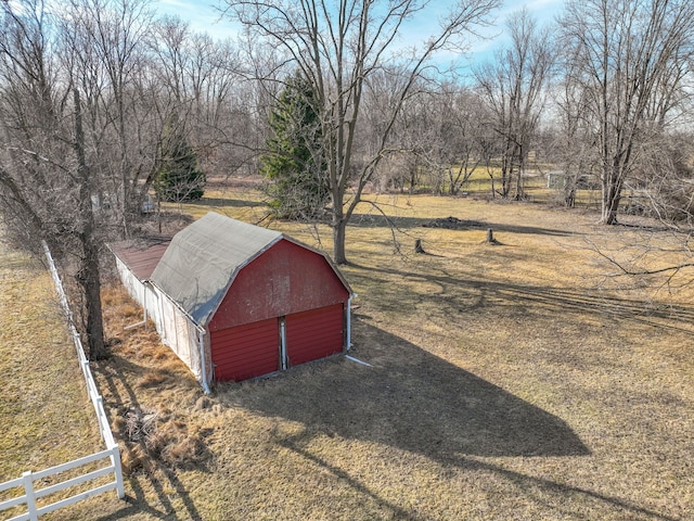 exterior space featuring a barn, a garage, an outbuilding, and fence