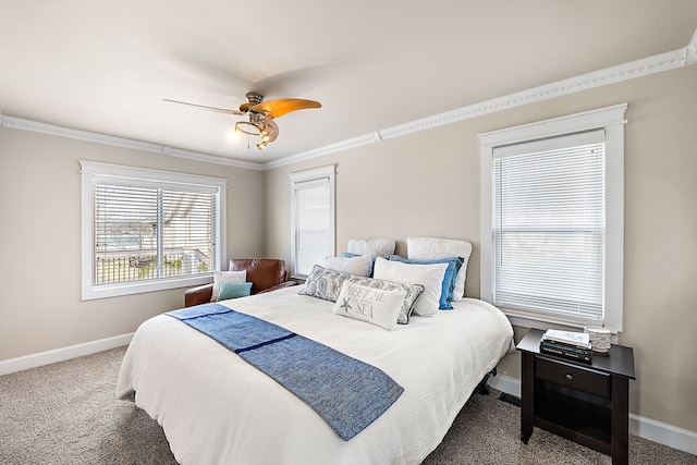 carpeted bedroom with ceiling fan, crown molding, and baseboards