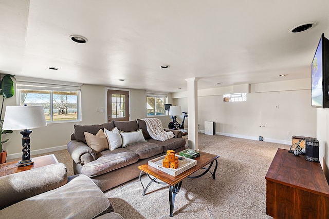 carpeted living room with decorative columns, a healthy amount of sunlight, and baseboards