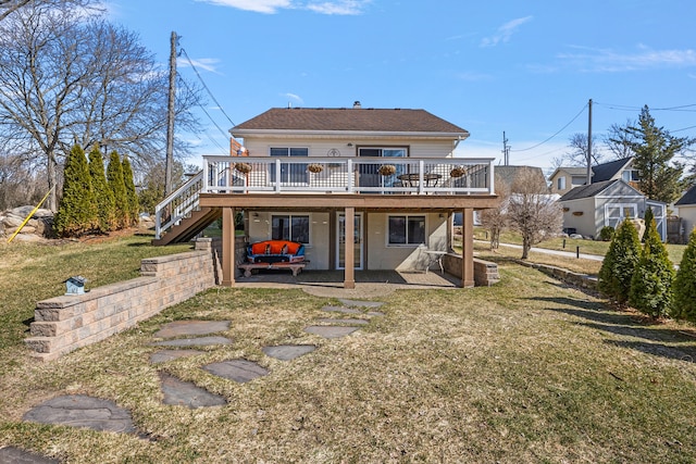 rear view of property featuring a deck, stairway, a patio area, and a lawn