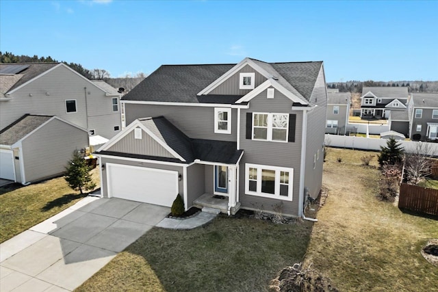 traditional-style house with an attached garage, concrete driveway, a front yard, and fence