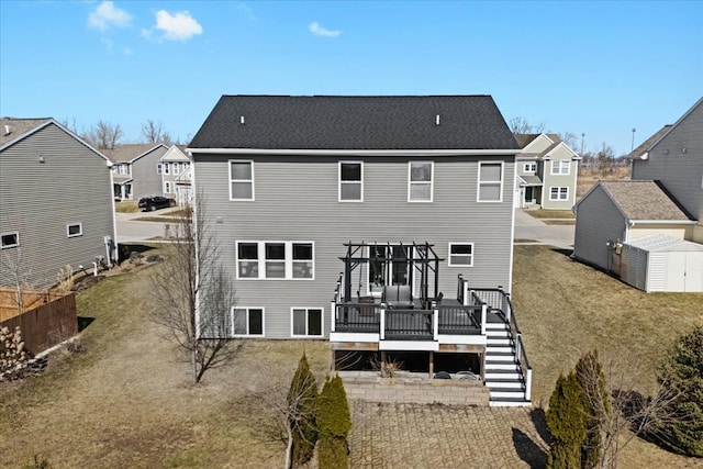 back of property featuring a deck, an outbuilding, a storage unit, and stairs