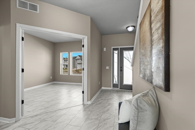 entrance foyer featuring visible vents, marble finish floor, baseboards, and a healthy amount of sunlight