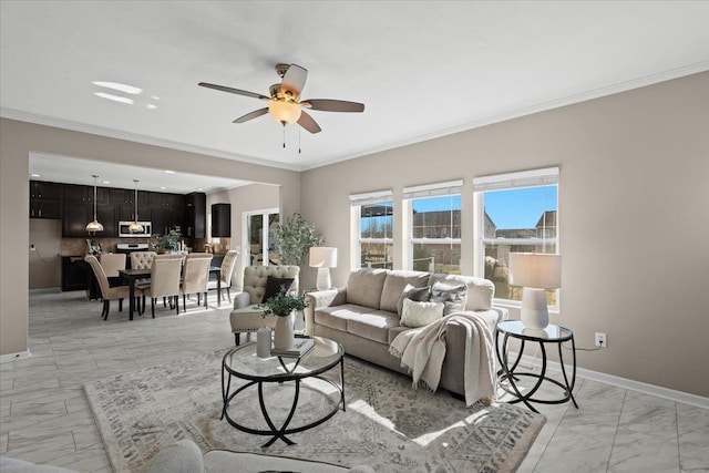 living area featuring baseboards, marble finish floor, a ceiling fan, and crown molding