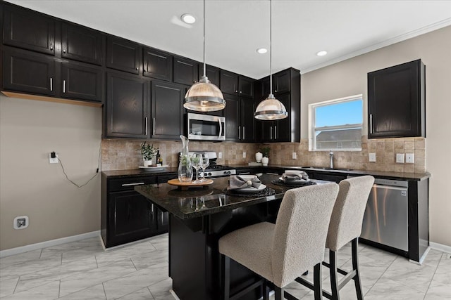 kitchen featuring marble finish floor, a sink, dark cabinetry, stainless steel appliances, and a breakfast bar area