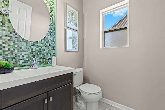 bathroom with vanity, baseboards, toilet, marble finish floor, and backsplash