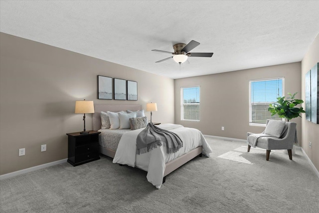 carpeted bedroom with baseboards, a textured ceiling, and a ceiling fan