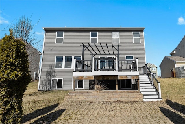 back of property featuring a deck, stairway, and a pergola