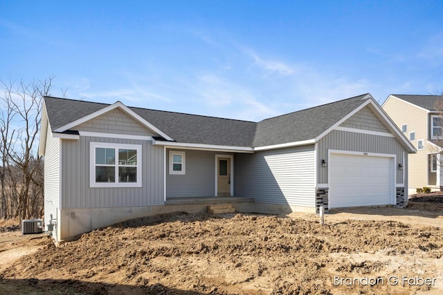 single story home featuring a garage, central AC, and roof with shingles