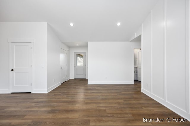 interior space featuring recessed lighting, baseboards, and dark wood finished floors