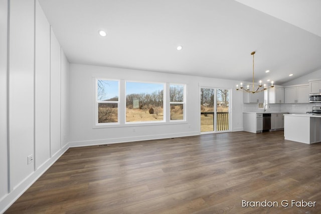 unfurnished living room featuring a healthy amount of sunlight, lofted ceiling, an inviting chandelier, and dark wood-style flooring