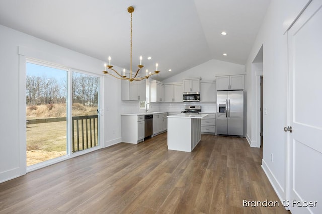 kitchen with dark wood-style floors, stainless steel appliances, decorative backsplash, light countertops, and a notable chandelier