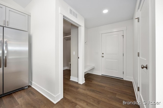 hallway featuring dark wood-type flooring, recessed lighting, baseboards, and visible vents